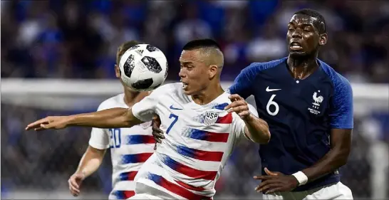  ?? (Photo AFP) ?? Paul Pogba s’accroche à l’attaquant américain Bobby Wood, symbole d’une rencontre compliquée pour les Bleus, à Lyon.