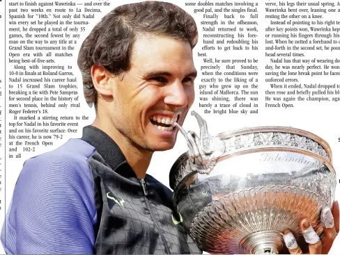  ??  ?? Spain's Rafael Nadal bites the trophy after defeating Switzerlan­d's Stan Wawrinka in their final match of the French Open tennis tournament at the Roland Garros stadium Sunday in Paris. Nadal has won his record 10th French Open title, beating No. 3...