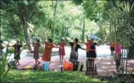  ?? PHOTOS BY WANG DONGMING / CHINA NEWS SERVICE ?? Left and right: Residents dance while others feed pigeons in a park beside Yundang Lake in Xiamen, Fujian province.