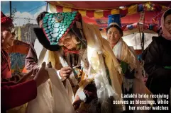  ??  ?? Ladakhi bride receiving scarves as blessings, while her mother watches