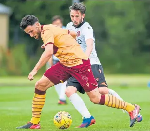  ?? Picture: SNS Group. ?? United’s Nicky Clark puts pressure on Motherwell’s Ricki Lamie during Saturday’s friendly at Dalziel Park.