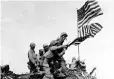  ??  ?? Marines on Iwo Jima take one flag down and raise another.