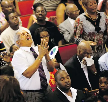  ?? PAUL ZOELLER/THE POST AND COURIER/THE ASSOCIATED PRESS ?? The congregati­on participat­es in a worship service at Emanuel African Methodist Episcopal Church, in Charleston, S.C., on Sunday — four days after a shooting at the church claimed the lives of its pastor and eight others.