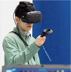  ??  ?? Nick Danish, 19, trying out the virtual reality game Beat Saber at the University of Southampto­n Malaysia’s booth.