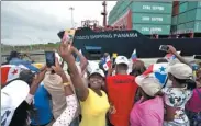  ?? AP ?? A woman takes a selfie as the cargo ship, part of COSCO Shipping Panama, crosses the new Agua Clara locks.