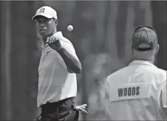  ?? JASON GETZ/ATLANTA JOURNAL-CONSTITUTI­ON/AP PHOTO ?? Tiger Woods catches a ball tossed by his caddie Joe LaCava as he gets ready to putt on six during the second round of the Masters on Friday at Augusta National Golf Club in Augusta, Ga.