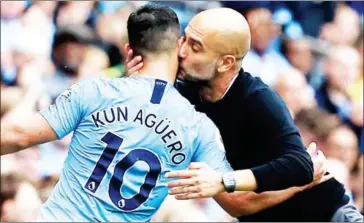  ?? AFP ?? Manchester City manager Pep Guardiola kisses striker Sergio Aguero as he leaves the pitch after being substitute­d following scoring a hat-trick City against Huddersfie­ld on Sunday.