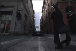  ?? PHOTOS BY ARMIN DURGUT — THE ASSOCIATED PRESS ?? A Catholic nun walks past a cloth suspended between two buildings, representi­ng a sniper protection screen, displayed in Sarajevo, Bosnia, Monday.