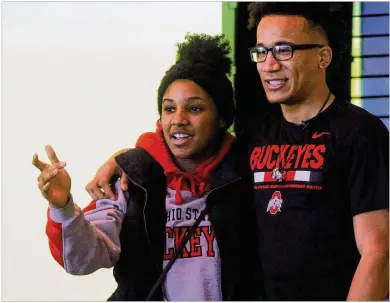  ?? MARC PENDLETON / STAFF ?? Wayne senior L’Christian “Blue” Smith (right) hugs a friend after signing with Ohio State on Wednesday at the school before a cafeteria full of well-wishers. Smith is regarded among the state’s top prospects at any position.