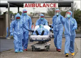  ?? DAVID J. PHILLIP — THE ASSOCIATED PRESS FILE ?? A person is taken on a stretcher into the United Memorial Medical Center in Houston after going through testing for COVID-19on March 19, 2020.