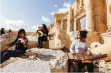  ??  ?? Syrian musicians play at the site of the damaged Roman amphitheat­er.