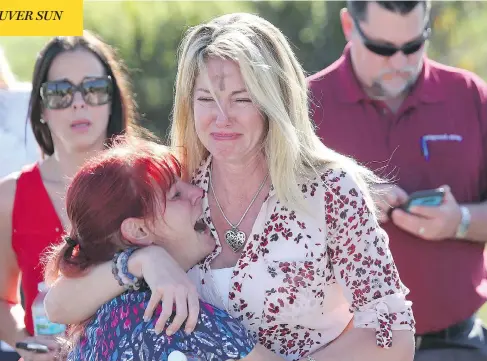 ?? JOEL AUERBACH / THE ASSOCIATED PRESS ?? Distraught parents wait for news after reports of a shooting spree at Marjory Stoneman Douglas High School in Parkland, Fla., on Wednesday.