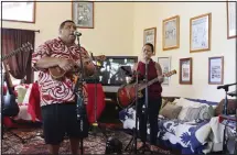 ??  ?? This file photo shows Lance Chang, left, singing and playing ukulele with his aunt NJ Chang, right, singing and playing guitar during a livestream performanc­e of their family’s band, Kanilau, from the living room of Lance’s
father home in Honolulu. (AP)