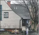  ??  ?? A Black Lives Matter sign hangs from the Universali­st Meetinghou­se in Amherst, Mass.