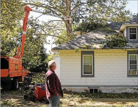  ?? JOHN STRICKLER — THE MERCURY ?? Tim Korn looks up at the damage to his home at 370 Green St. in Royersford after a severe storm and high winds snapped a large branch from the sycamore tree in his yard. Korn had damage on the roof of the home and garage. His windshield on his truck...