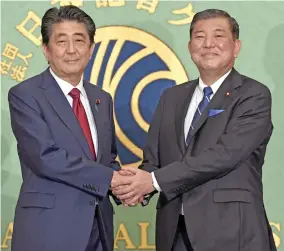  ?? Photo: Kyodo ?? Japanese Prime Minister Shinzo Abe and former Defense Minister Shigeru Ishiba shake hands in Tokyo on September 20, 2018.