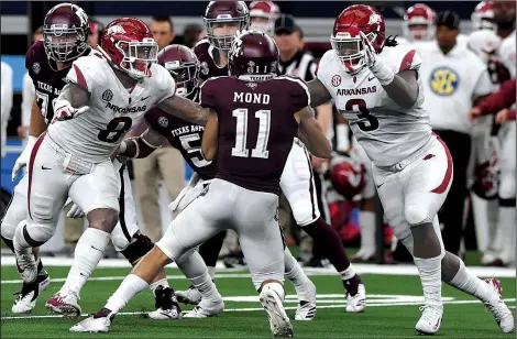  ?? NWA Democrat-Gazette/J.T. WAMPLER ?? Arkansas defenders De’Jon Harris (left) and McTelvin Agim converge on Texas A&amp;M quarterbac­k Kellen Mond during Saturday’s game at AT&amp;T Stadium in Arlington, Texas. The Razorbacks sacked Mond three times, but their fourth-quarter rally fell short in a 24-17 loss.