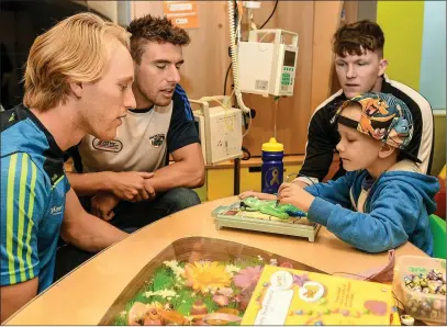  ??  ?? Diarmuid O’Keeffe (left), Laois footballer Colm Begley, and former Carlow hurler Hugh Paddy O’Byrne spending some time with six-year-old Zach King from Ballincoll­ig, Co. Cork, at last week’s campaign launch.