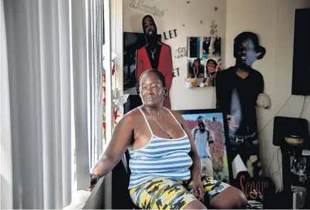  ?? ARMANDO L. SANCHEZ/CHICAGO TRIBUNE ?? Shirley Moten near photograph­s of her sons in her home July 7 in Chicago. Her sons, pictured behind her from left are Mark Blakely, who was fatally shot in 2020; Hakeem Murry, who was fatally shot in 2017; and James Johnson, known as Troy, was fatally shot in 2017.