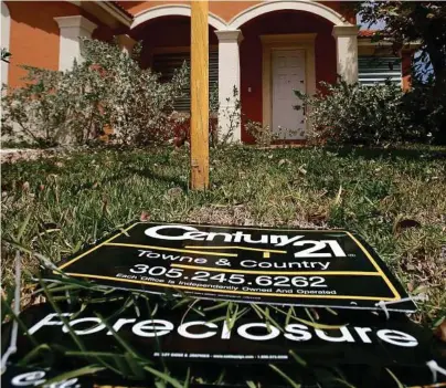  ??  ?? J Pat Carter / AP
A sign lies on the ground in front of a foreclosed home in Homestead, Fla. The number of borrowers falling behind on their mortgage payments dropped sharply at the end of 2009.