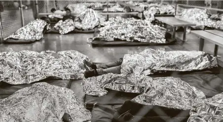  ?? Carolyn Van Houten / Washington Post file photo ?? Male minors rest under Mylar blankets in the Border Patrol Central Processing Center in McAllen in August 2019.