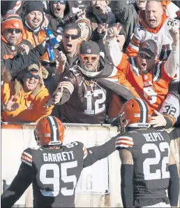  ?? RON SCHWANE – THE ASSOCIATED PRESS ?? Browns defensive end Myles Garrett celebrates with fans after scooping up a fumble on a strip sack and returning it for a second-quarter touchdown against the Ravens.