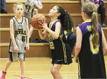  ?? ?? Bunyip Spirits player Sophia Rea takes a free throw as Drouin Hearts player Ivy McCallum and Sophia’s teammate Lara Briggs watch on.