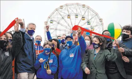  ?? John Minchillo The Associated Press ?? New York City Mayor Bill de Blasio, left, attends the ribbon cutting and seasonal opening of the Coney Island amusement park area on Friday in Brooklyn. It has six new attraction­s for youngsters coming online this year, according to its website.