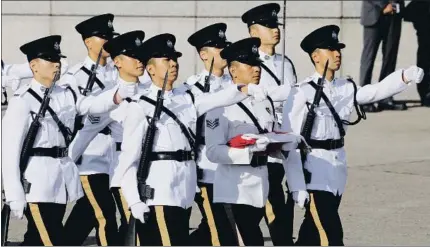  ?? ANTHONY KWAN / BLOOMBERG ?? La guardia de honor de la policía, con la bandera actual de Hong Kong en la ceremonia celebrada ayer