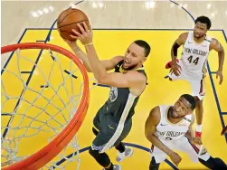  ?? AP ?? Stephen Curry of Golden State Warriors lays up a shot over Ian Clark (right) and Solomon Hill (44) of New Orleans Pelicans during Game 2 of their second-round NBA basketball playoff series in Oakland. GSW won 121-116. —