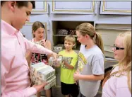  ?? Arkansas Democrat-Gazette/RICK McFARLAND ?? Jackson Matayo, with the state treasurer’s office, hands stacks of money to fifth-grade students (from left) McKenna Lunsford, Titus Haggard, Kenzie Blanchard and Madison Finley during a tour of the state Capitol on Wednesday. The Corning Central...