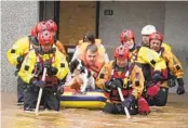  ?? ANDREW MILLIGAN AP ?? Members of the emergency services evacuate residents from a flooded area in Brechin, Scotland, Friday.