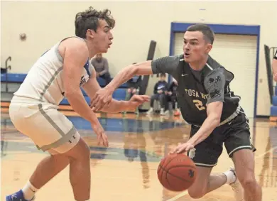  ?? MARK STEWART/MILWAUKEE JOURNAL SENTINEL ?? Wauwatosa West’s Cole Hansen handles the ball as Brookfield Central’s Drew Edmond defends on Tuesday night. Hansen is the second-highest scorer at 13.8 points per game for the Trojans, who are off to a 7-2 start this season.