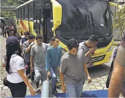  ??  ?? Retornados. Salvadoreñ­os deportados ingresan al centro de inmigració­n en la colonia La Chacra, en la capital. Fueron detenidos en EUA.