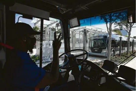  ?? Yi-Chin Lee / Staff photograph­er ?? Johnny Finley Jr. waves at the driver in the opposite direction Sunday as he drives the Silver Line bus rapid transit route on Post Oak Boulevard. Fourteen 60-foot buses will operate the Silver Line route, including traveling along an elevated busway.