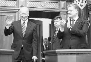  ?? Mikhail Palinchak / The Associat ed Press ?? Ukrainian President Petro Poroshenko, right, applauds U. S. Vice President Joe Biden, left, after Biden addressed the Ukraine Parliament in Kiev on Tuesday.