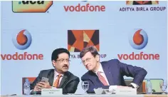  ??  ?? Kumar Mangalam Birla (left), chairman of Aditya Birla Group, speaks to Vittorio Colao, CEO of Vodafone Group, during a news conference in Mumbai, India March 20. — Reuters photo