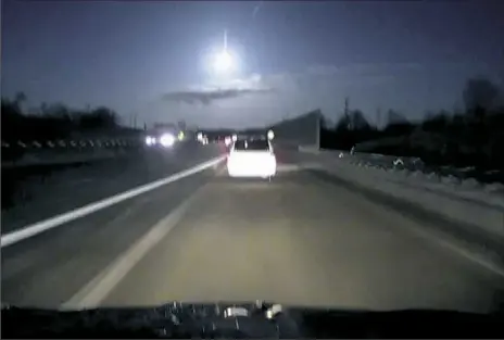  ?? Zack Lawler/WWMT via AP ?? In this image made late Tuesday from dashcam video, a brightly lit object falls from the sky above a highway in the southern Michigan skyline.