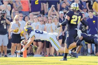  ?? MICHAEL CONROY/ASSOCIATED PRESS ?? Michigan tight end Zach Gentry, left, an Eldorado High alumnus, dives for a touchdown in front of Purdue linebacker Markus Bailey in the first half of their game Saturday.
