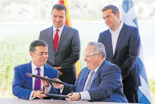  ??  ?? Makedonski šef diplomacij­e Nikola Dimitrov (lijevo) s grčkim kolegom Nikosom Kotziasom razmijenio je potpisani sporazum o priznanju imena Sjeverna Makedonija, a sve su nadzirali premijeri Zoran Zaev i Alexis Tsipras