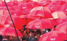  ?? AFP ?? SOUTH KOREAN unionized workers carry red umbrellas during a May Day rally in Seoul on May 1. Thousands of South Koreans took part in May Day protests demanding more labor rights and to call for a higher minimum wage.