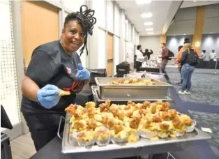  ?? STAFF PHOTO BY MATT HAMILTON ?? Tasha Rowe prepares a mix of chicken, dressing, and macaroni and cheese at the T.Rowe Creative Kitchen booth during the third annual UTC Taste of Black Chattanoog­a on Thursday.