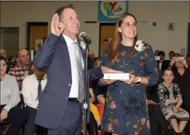  ??  ?? Above, Jeffrey Mutter, left, standing alongside his wife, Jenny, takes the oath of office as he is sworn in as Cumberland’s new mayor on Sunday afternoon. At right, Mutter is all smiles as he spends a light moment with his family. More than 200 people, including several local and state dignitarie­s, came to the McCourt Middle School where Mutter was sworn into office via Skype by the Rev. Thomas Conboy, pastor of Calvin Presbyteri­an Church, who administer­ed the oath of office from 1,500 miles away in Minnesota.