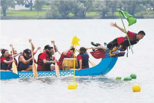  ?? Photos by Hyoung Chang, The Denver Post ?? Brandon Vue, right, leads a team called Got Dimsum in the flag-catching division of the 18th annual Dragon Boat Festival at Sloan’s Lake on Saturday.