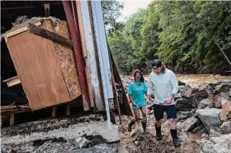  ?? Richard Beaven/New York Times ?? Bex Prasse and Craig Kovalsky assess the flood damage to their property on Main Street in Ludlow, Vt. Prasse and Kovalsky had worked nearly a year to restore their home.