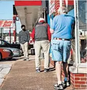  ?? TROY STOLT/CHATTANOOG­A FREE TIMES ?? Three men employing social distancing wait to get haircuts Wednesday outside a Hixon, Tennessee, barber shop.