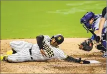  ?? Gregory Bull Associated Press ?? THE PADRES’ Trent Grisham, left, is tagged out at the plate by Dodgers catcher Will Smith to close L.A.’s 7-6 win Wednesday.