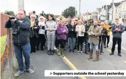  ??  ?? &gt; Supporters outside the school yesterday