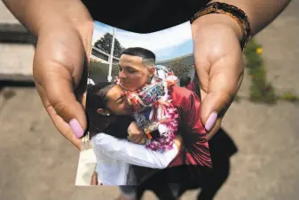  ?? Santiago Mejia / The Chronicle ?? Ashley Monterrosa holds a photo of herself hugging brother Sean at the latter’s 2016 graduation. Sean Monterrosa, 22, was fatally shot by Vallejo police early Tuesday.