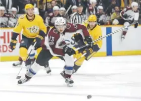  ??  ?? Avalanche center Alexander Kerfoot chases the puck ahead of Nashville Predators center Colton Sissons, left, and right wing Craig Smith on Tuesday night.